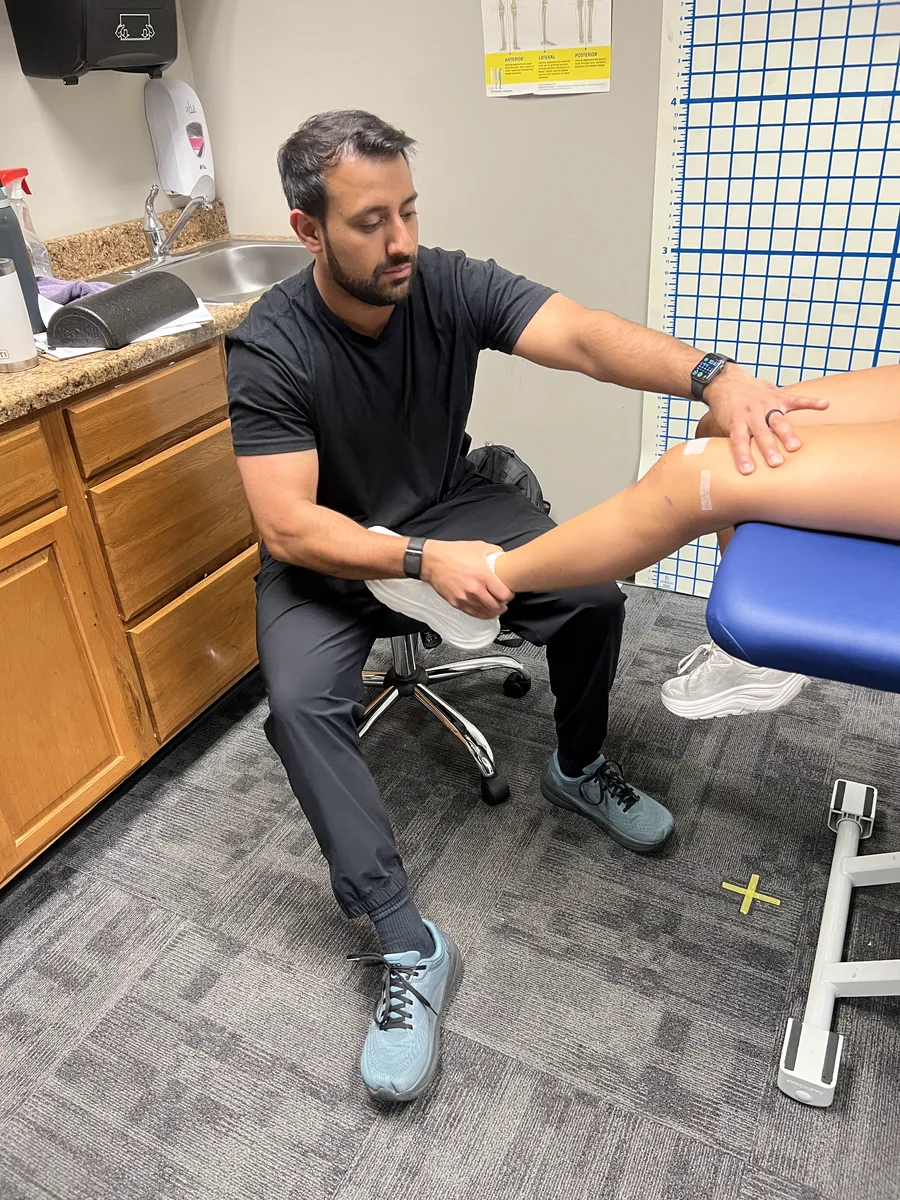 TJ assessing a patient’s knee during a one-on-one appointment