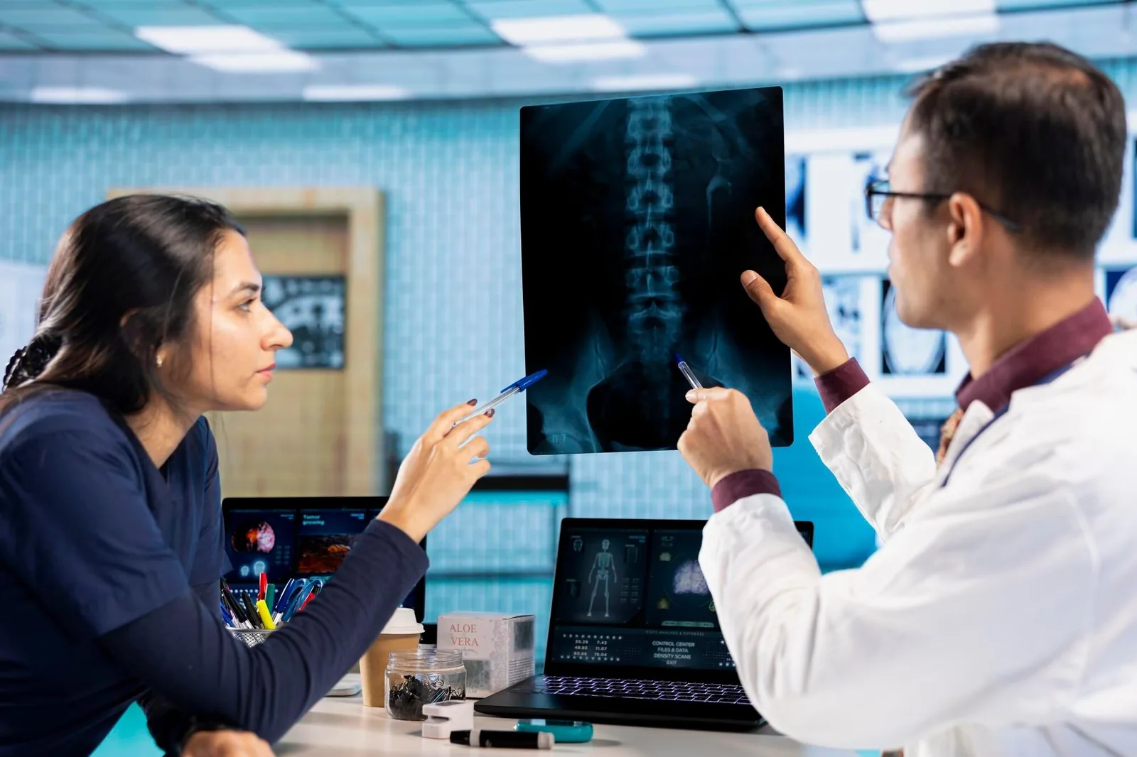 Two clinicians reviewing a spine X-ray