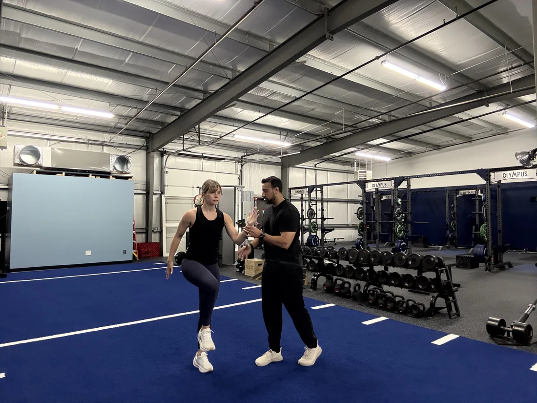 TJ and a patient discussing movement on the gym floor