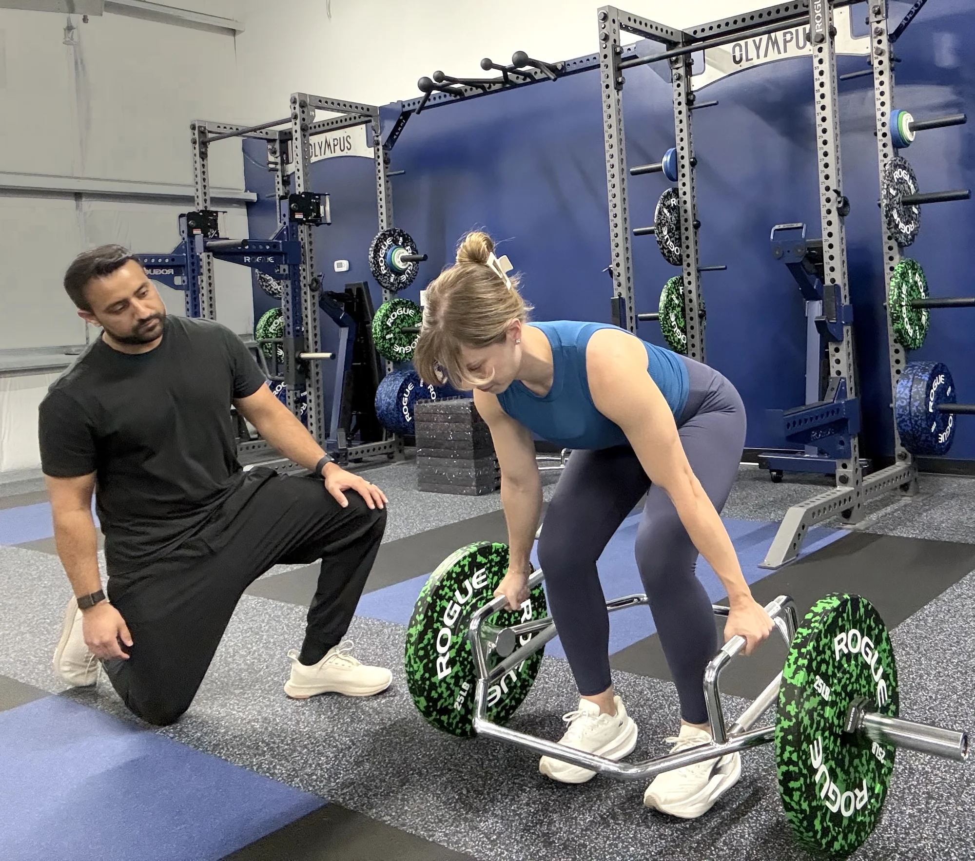 TJ coaching a patient through a trap-bar deadlift at the gym