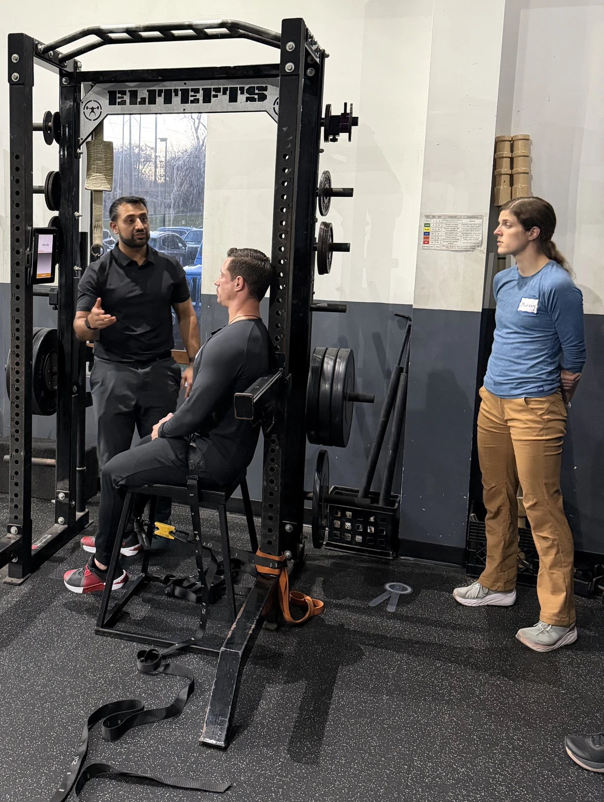 TJ demonstrating an exercise to clinicians at a squat rack