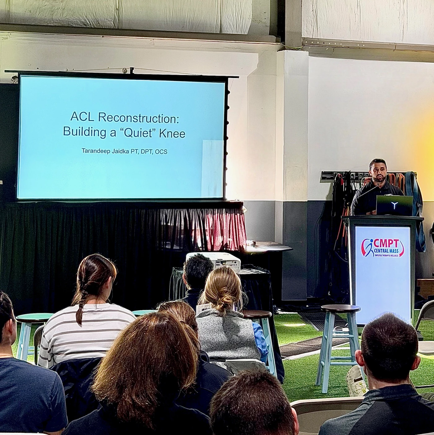 TJ presenting “ACL Reconstruction: Building a Quiet Knee” to a seated audience